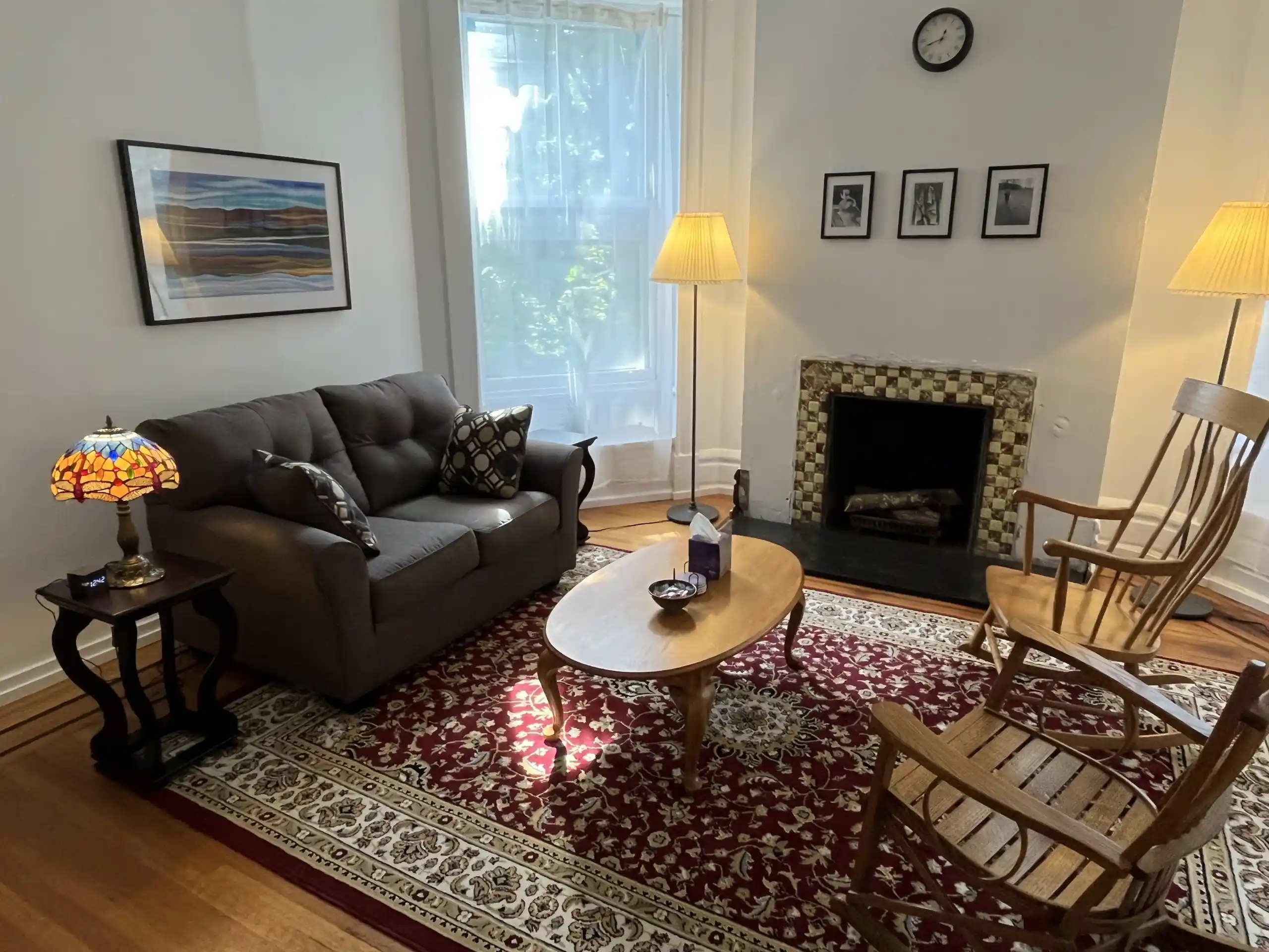 A cozy and welcoming therapy room for psychotherapy sessions featuring a sofa and fireplace.